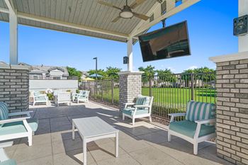a patio with chairs and a tv on a roof